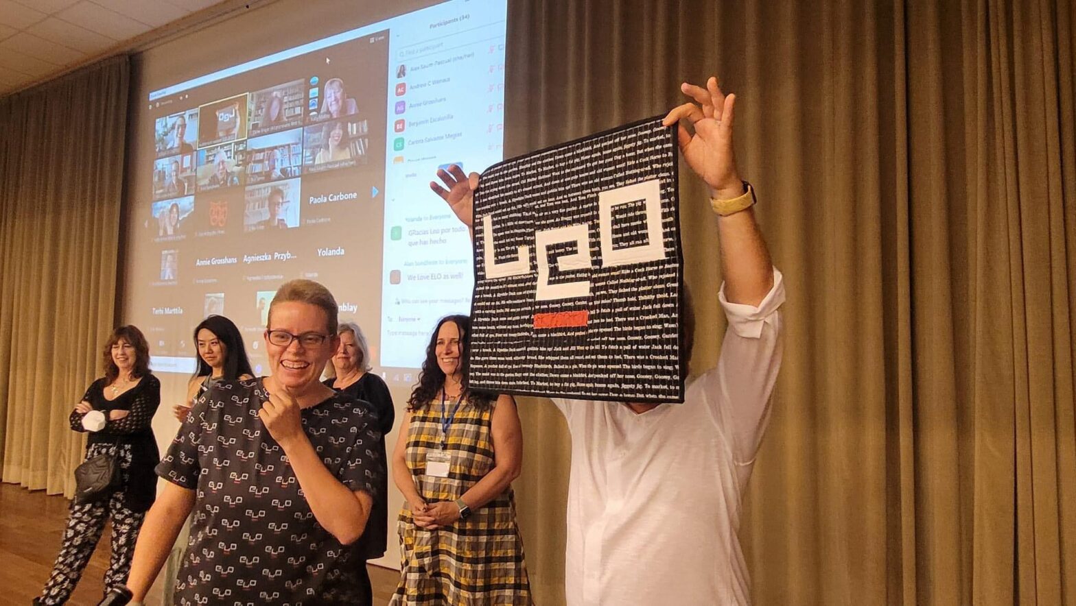 Image of me holding a quilt that spells LEO along with several fellow ELO Board Members